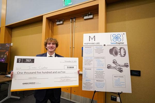 First-year student Andrew Murphy, who won first place in the Acceleration Track with IonoCopter, poses with his venture’s poster.