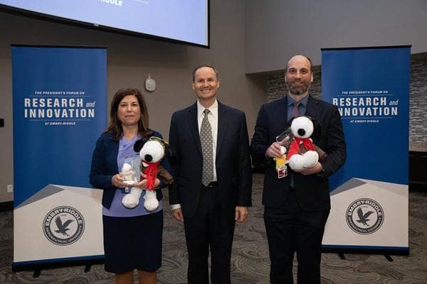 Aerospace Cybersecurity Excellence (ACE) award-winners Luci Holemans and Stefan Schwindt flanked Embry-Riddle's Center for Aerospace Resilient Systems executive director, Dan Diessner