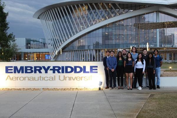 Group of students stand by the Embry-Riddle sign