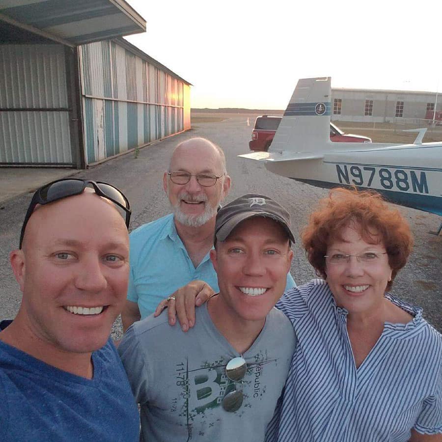 Matthew Henkel (center), his twin brother Nathan (left) and their parents Gary and Paty Henkel pose next to Matthew’s 1968 Mooney M-20C. 