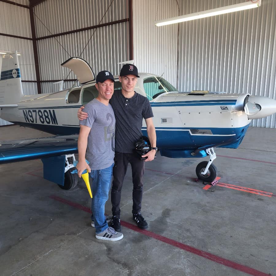 ): Matthew Henkel and his nephew Nathan, shown here in front of Matthew’s aircraft, will walk together during the August Worldwide Campus Commencement event in San Diego.