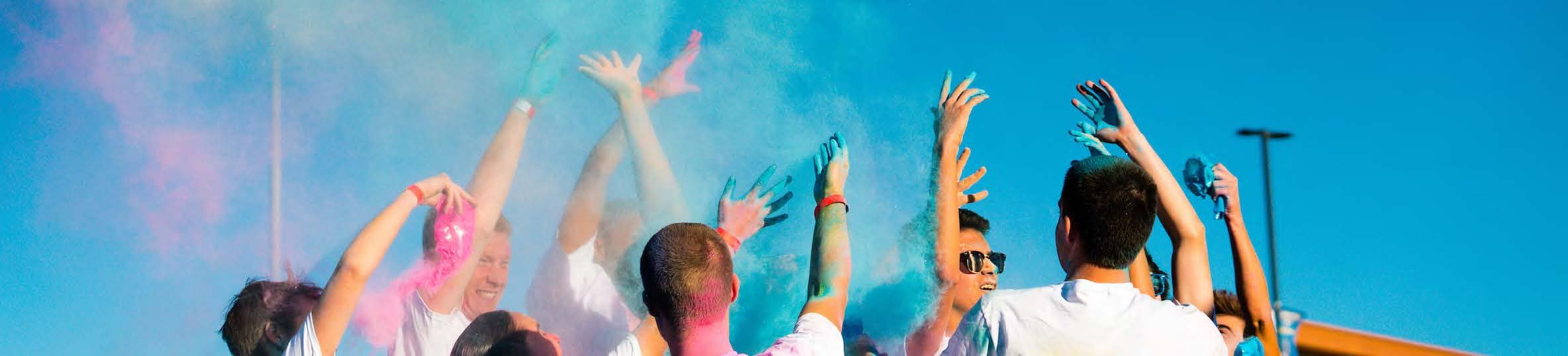 Students throwing colorful powder into the air.