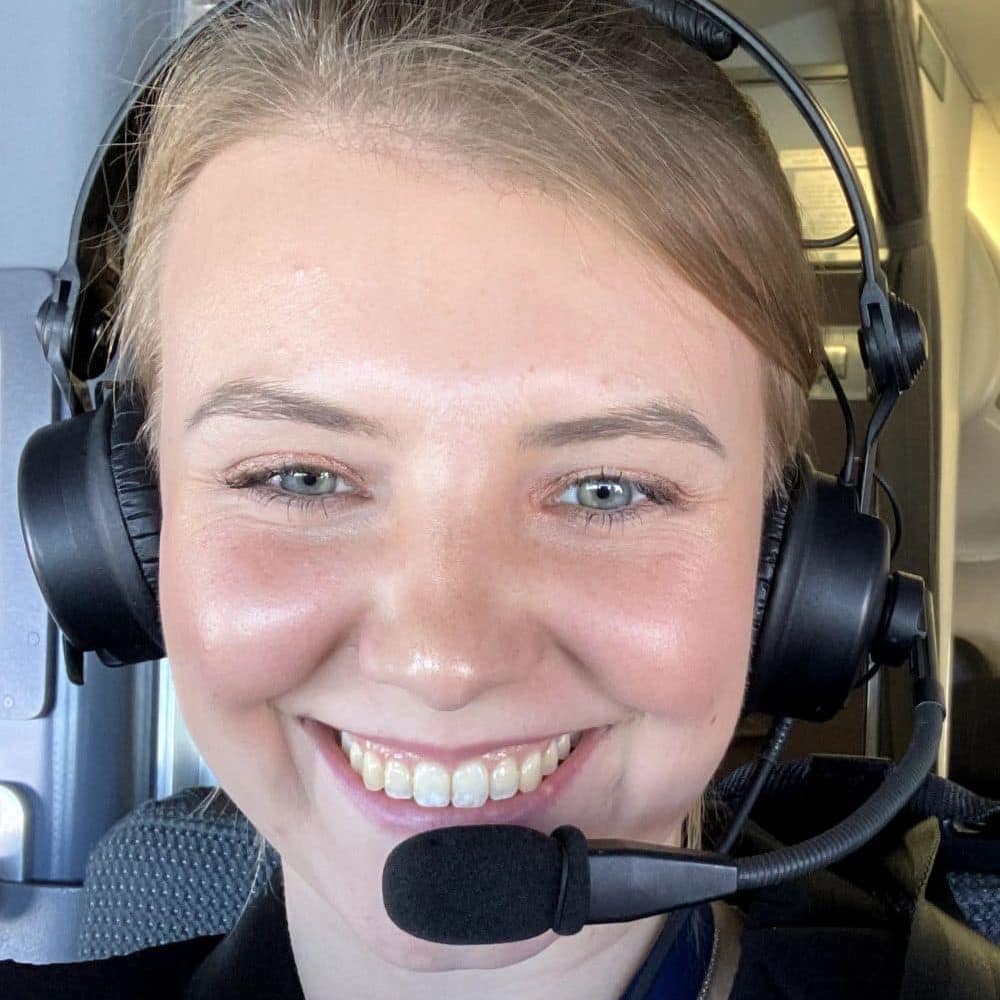 Megan Gill wearing a headset in the cockpit of a plane.