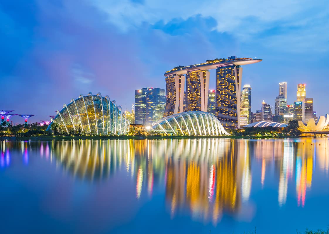 Singapore's skyline reflected in the water, at dusk.