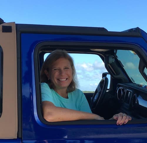 woman sitting in blue jeep