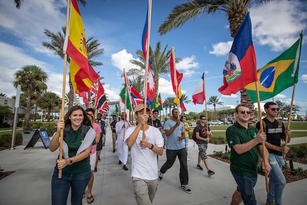 Embry-Riddle students carry flags representing numerous countries