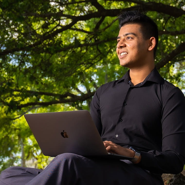 Student working on laptop computer in the sunny outdoors