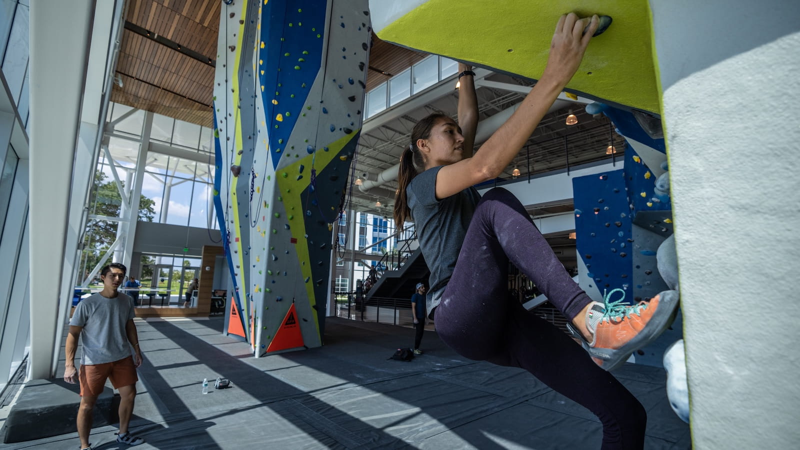 Student rock climbing at fitness center