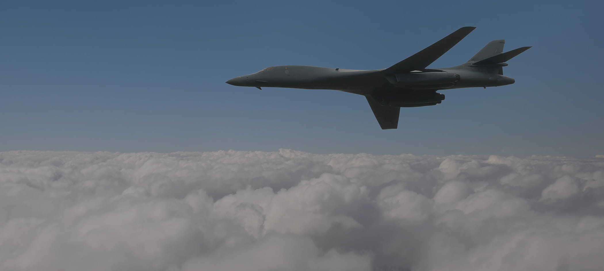A jet flies above clouds.