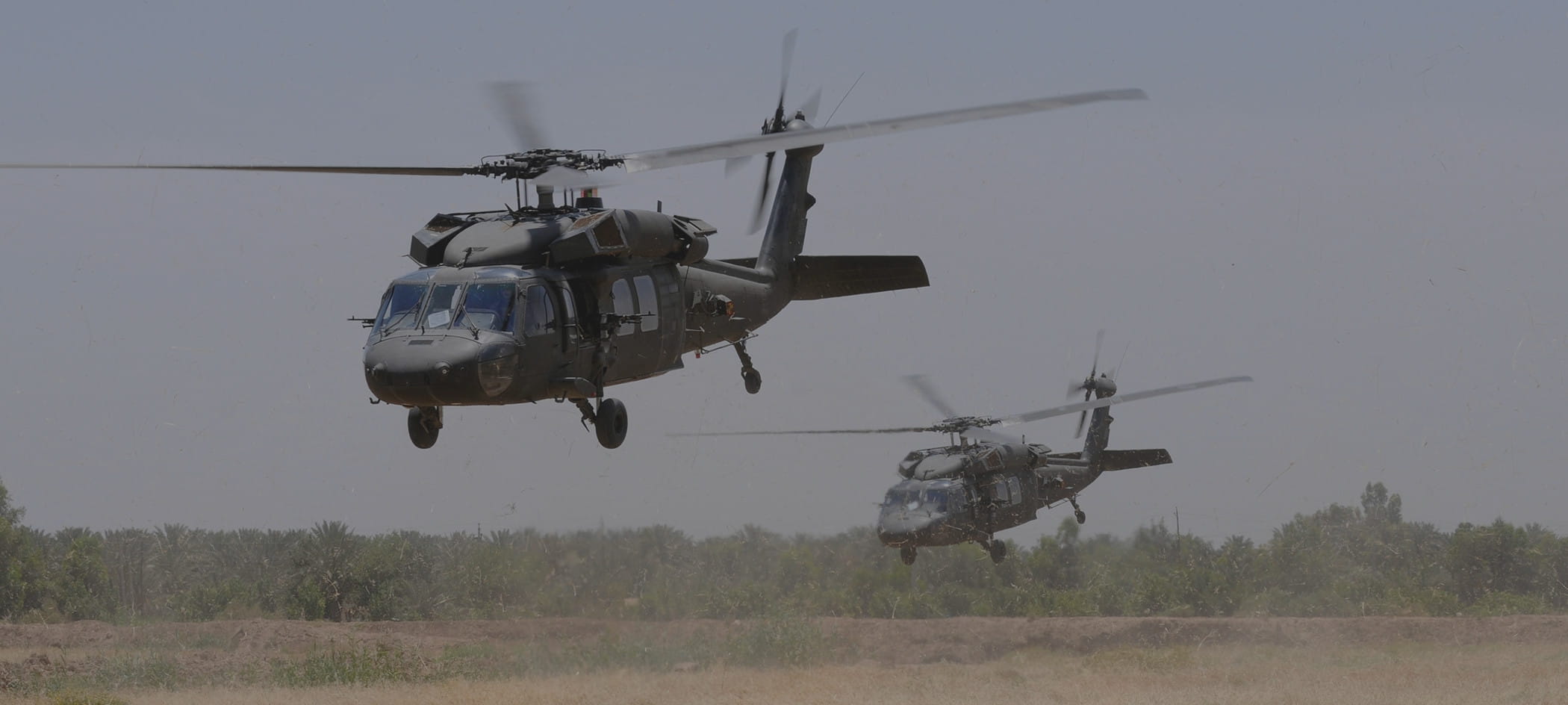 Two military helicopters take off.