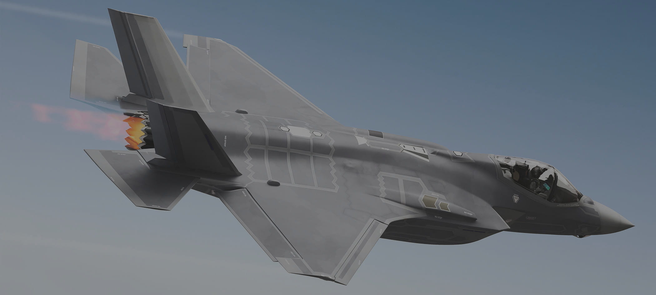 Military jet flies in blue sky.