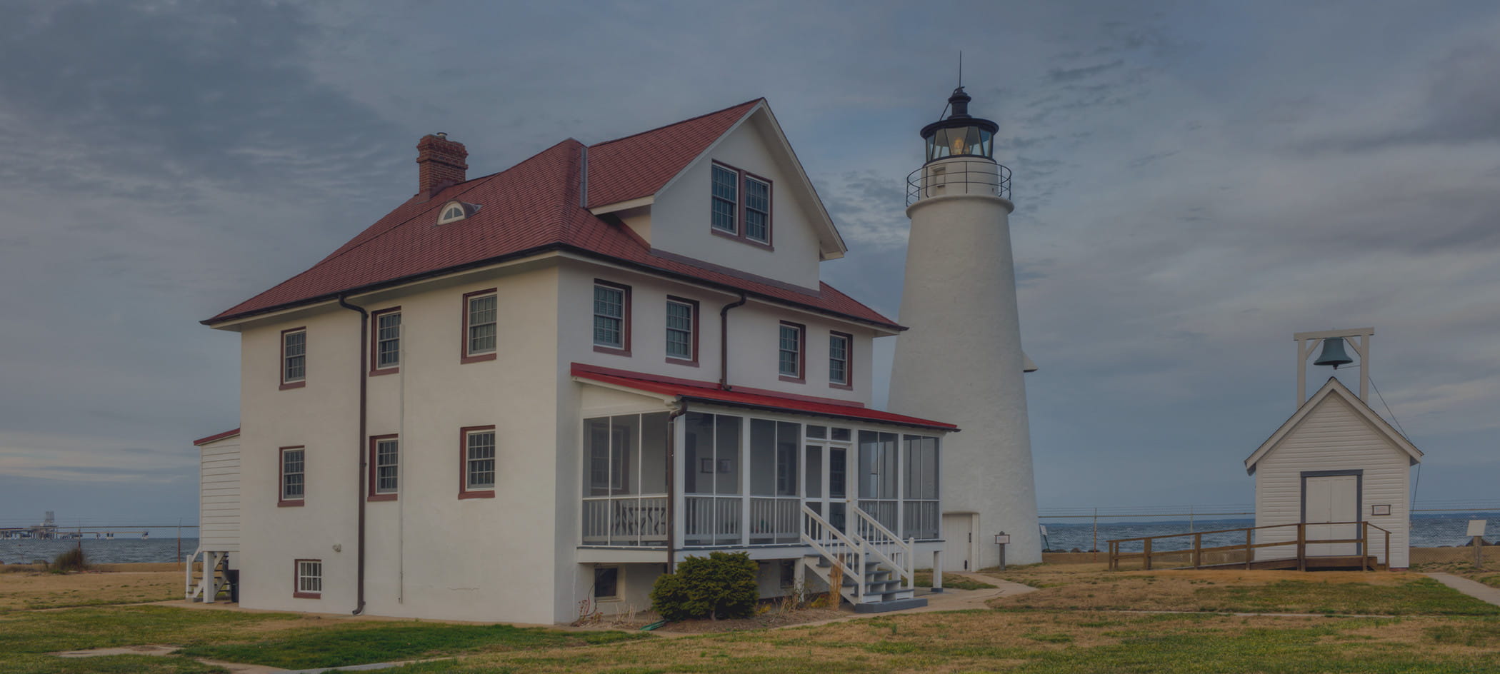 Old country house with lighthouse next to it.