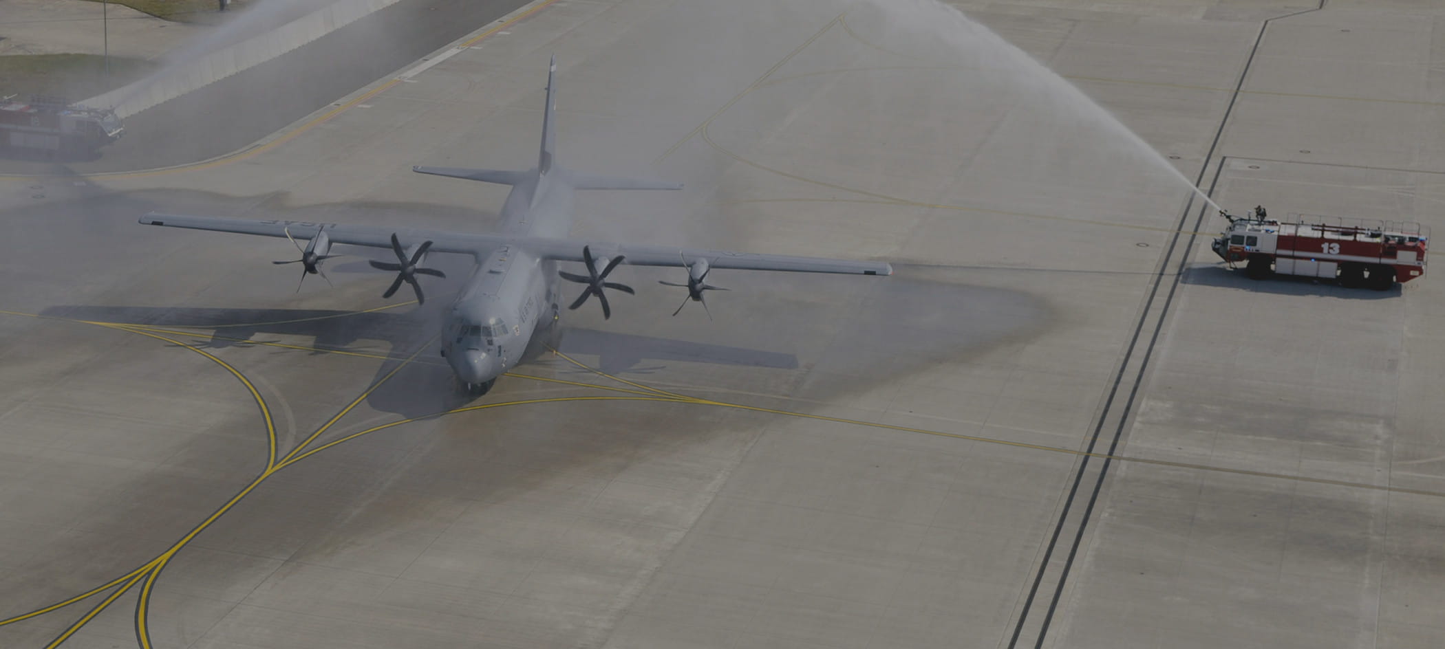 A firetruck sprays a cargo plane on runway.