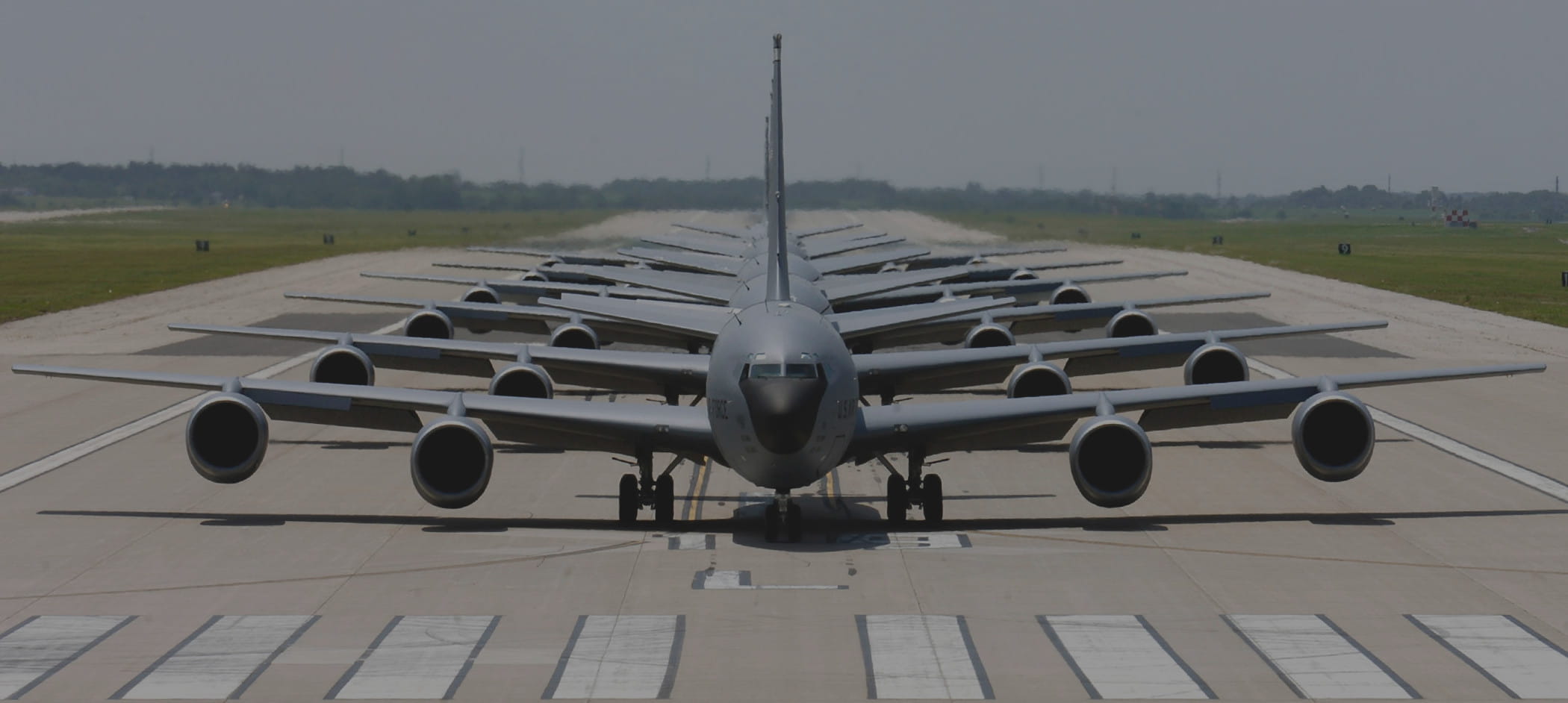 Multiple cargo plans lined up end-to-end on runway.