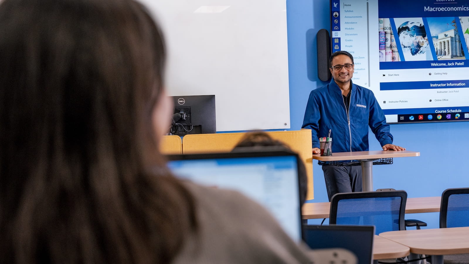 A faculty member stands in front of class