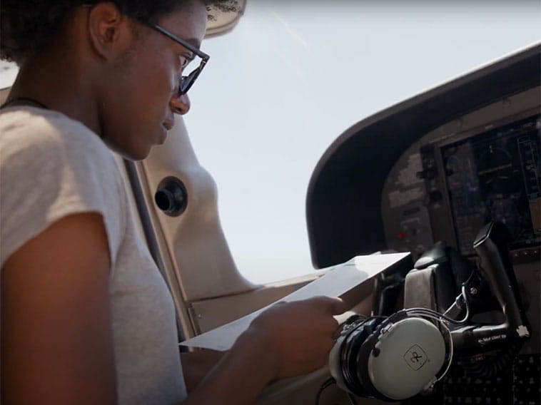 Student inside of a cockpit reading a checklist.