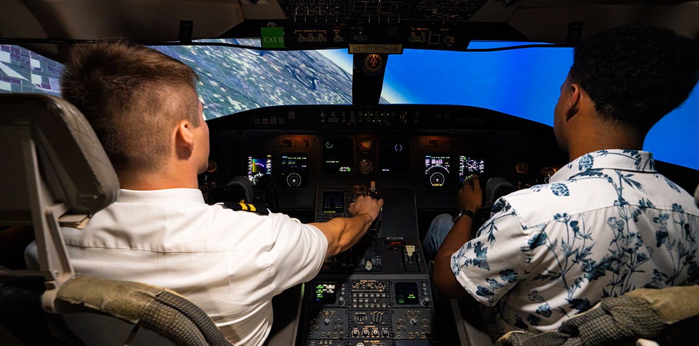 Two students inside a flight simulator
