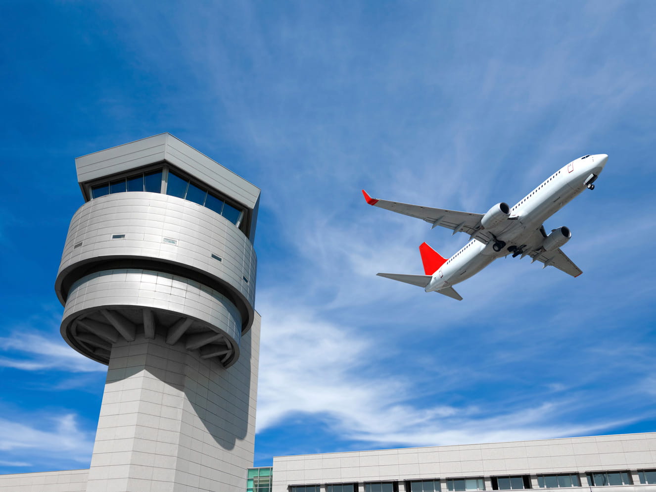 Commercial plane flies over air control tower.