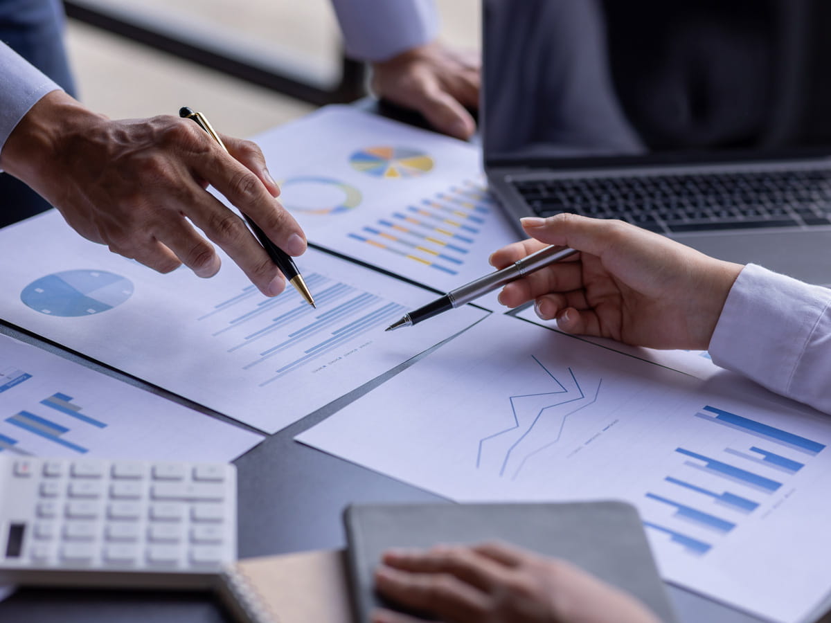 People looking at papers with charts and numbers.