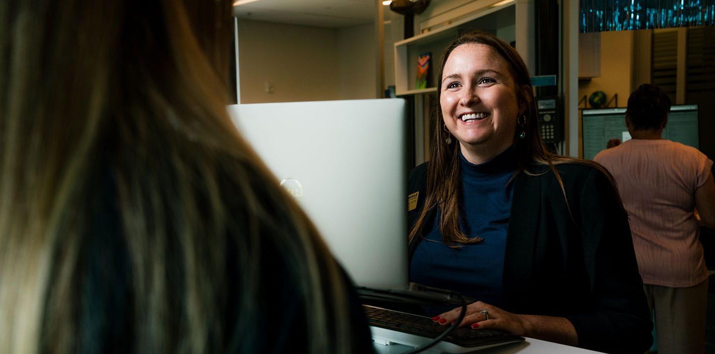 Woman smiling behind computer