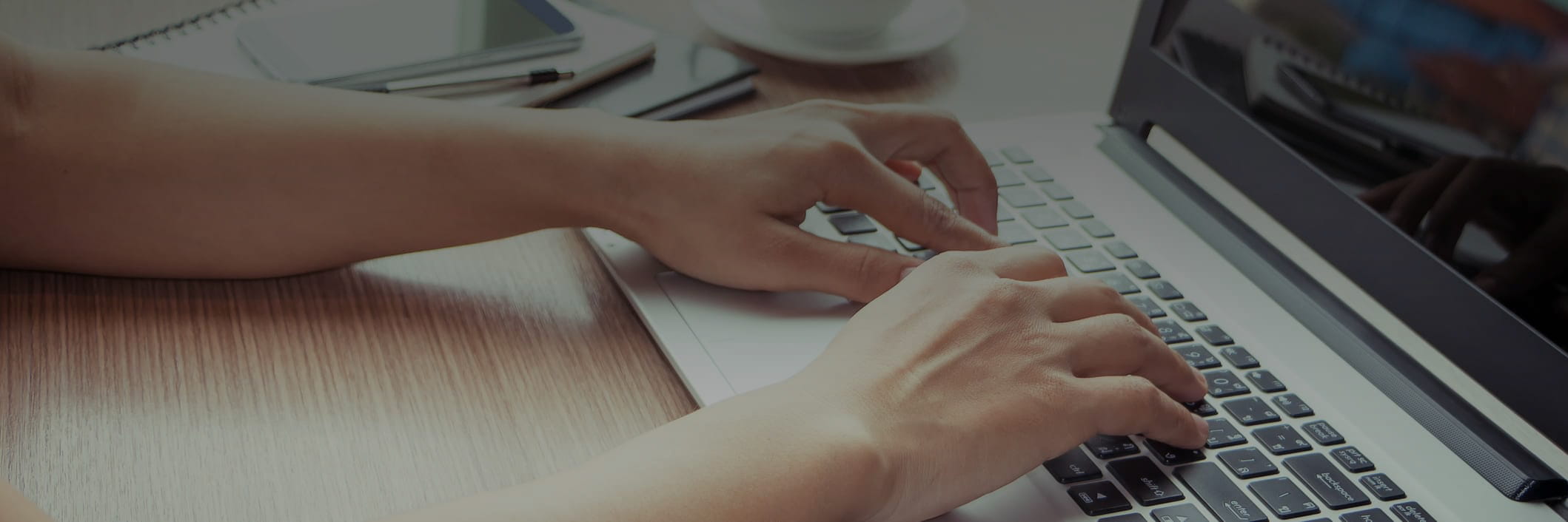 Hands typing on laptop