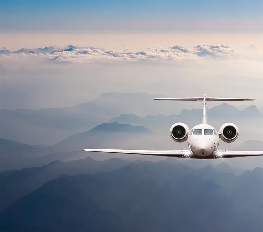 A private plane flies above the mountains