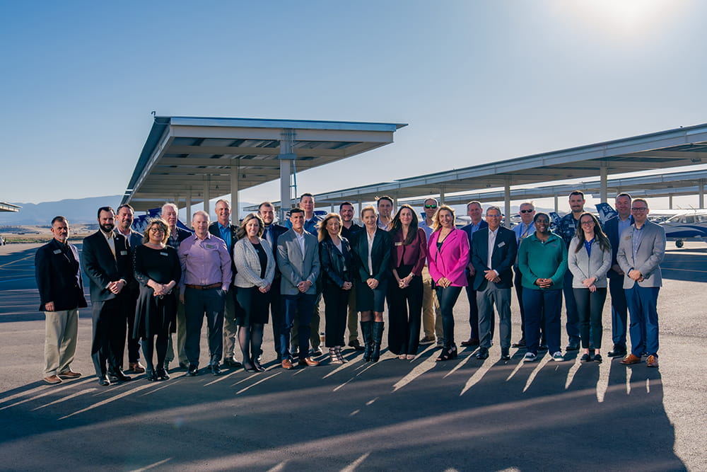 The Prescott College of Aviation Industry Advisory Board stands outside posing for a group photo
