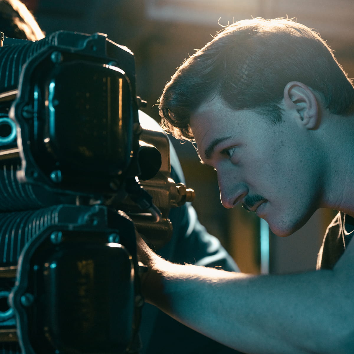Student inspecting aircraft engine components up close, focusing on mechanical parts and assembly.