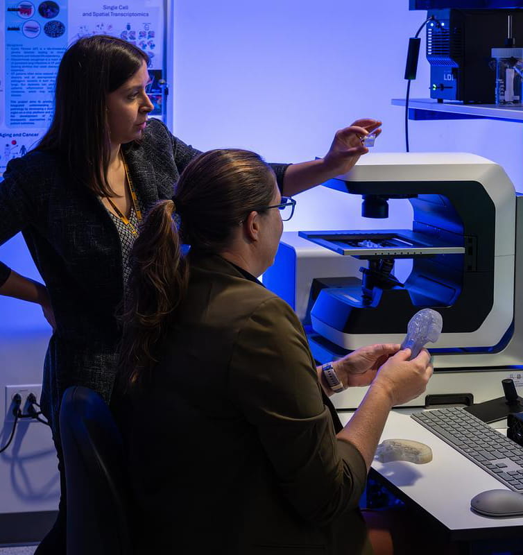 Women discussing data in a COAS Lab.