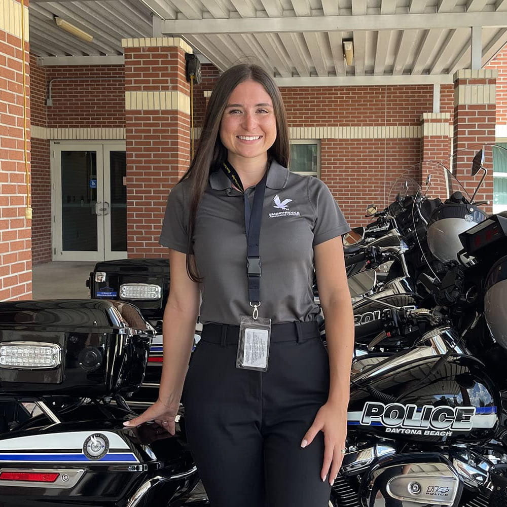 Hannah Wood stands next to a police motorcycle