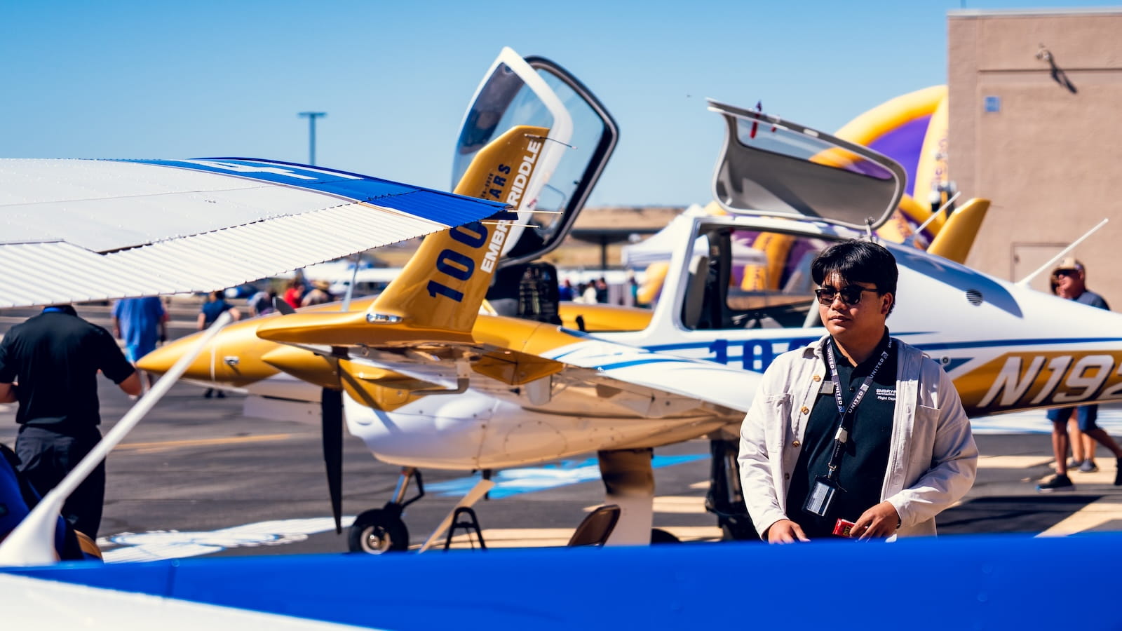 Embry-Riddle student stands on the tarmac in Prescott, Arizona near planes that are parked
