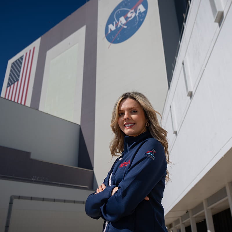 Alora Mazarakis stands in front of a NASA building posing for a photo