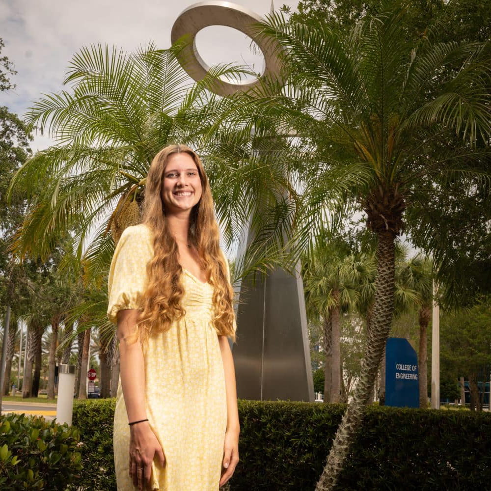 Sydney Makarovich stands ouside the Daytona Beach College of Aviation, surrounded by palm trees