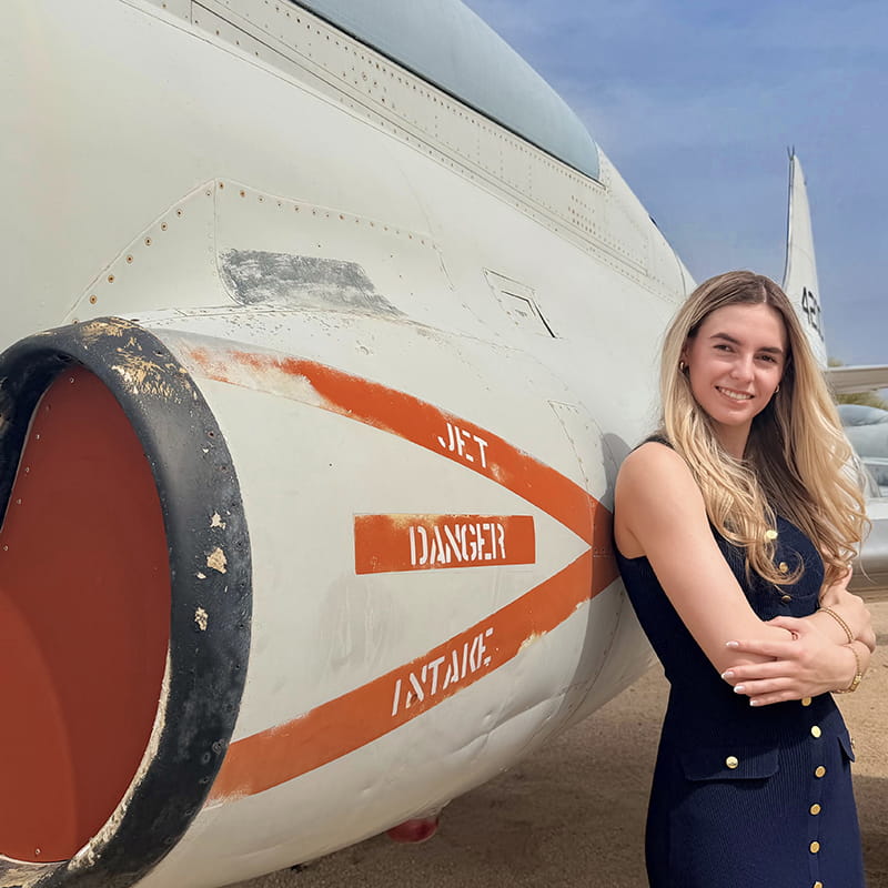 Rachel Swan stands next to a jet