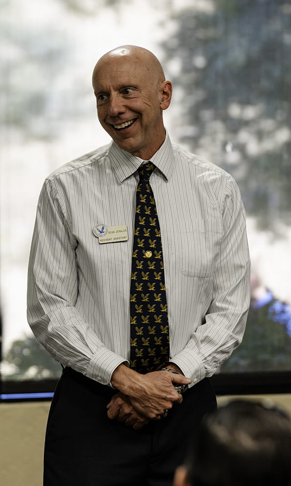 Sean Jeralds, an Embry-Riddle faculty member, stands at the front of a room in professional dress