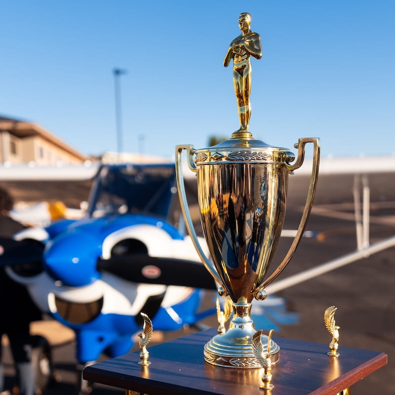 Golden Eagles trophy sits on a table in front of an Embry-Riddle plane