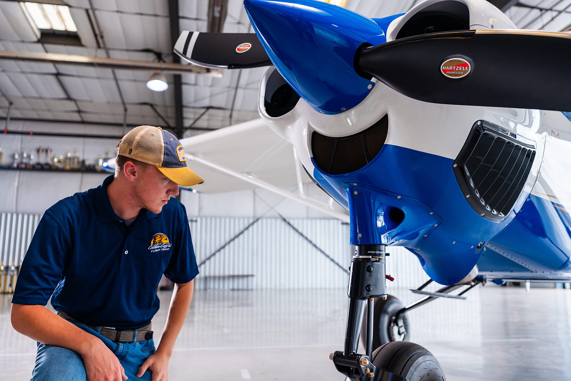 Embry-Riddle student inspects the wheel of a small plane in an airplane hangar