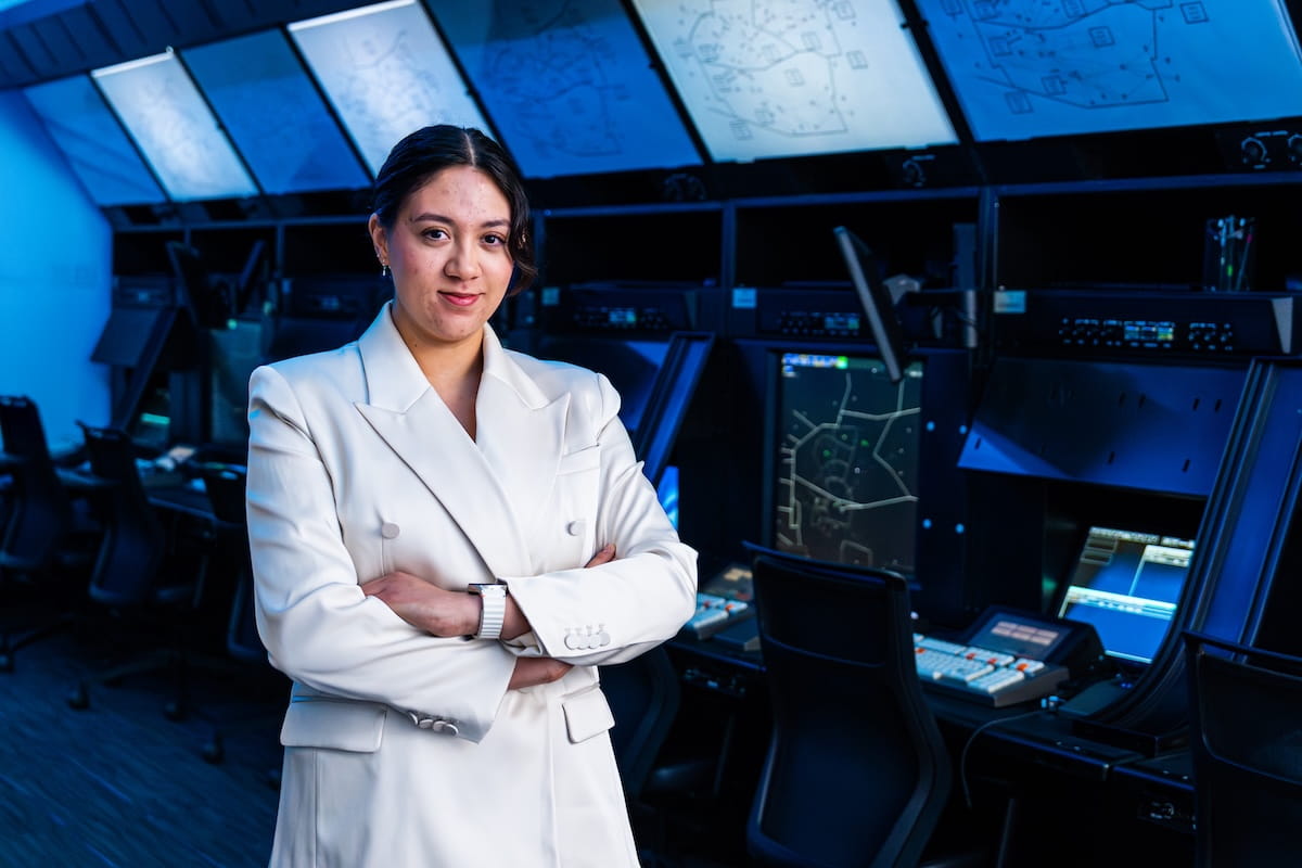 Francesca Keel stands in an air traffic control lab wearing a white lab coat