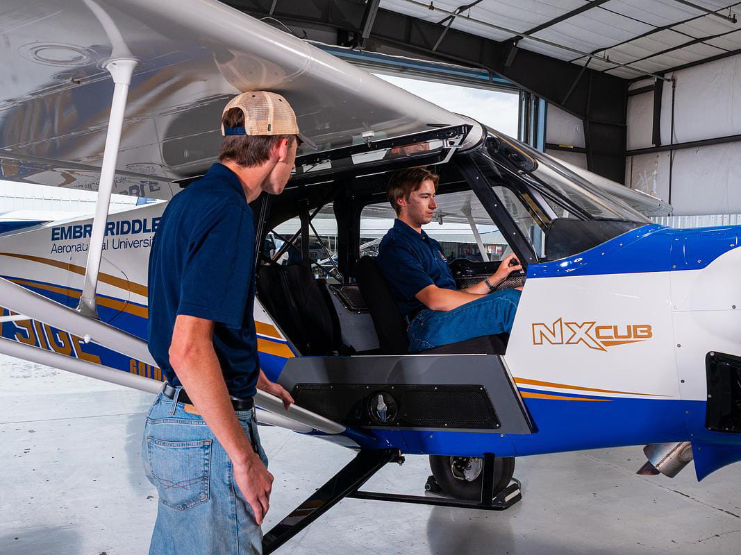 Students look at a plane in a hangar.
