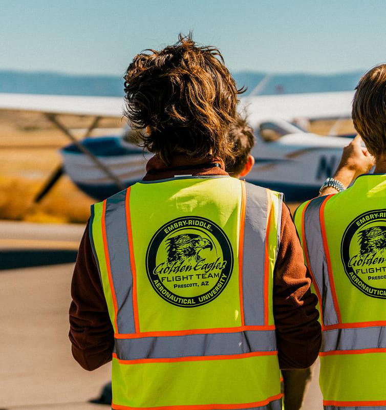 Flight team members looks at a plane on the runway.