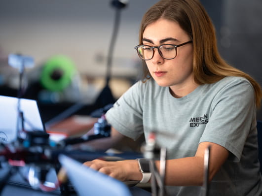 A person sitting at a desk, working on their laptop.