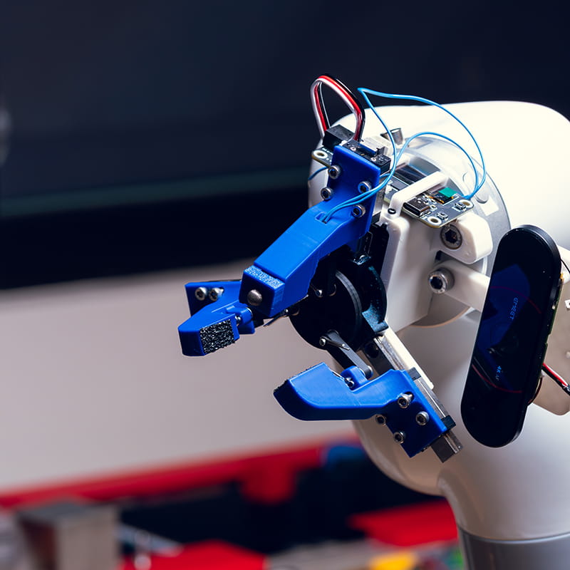 Robot with a gripping arm sits on a table in a lab
