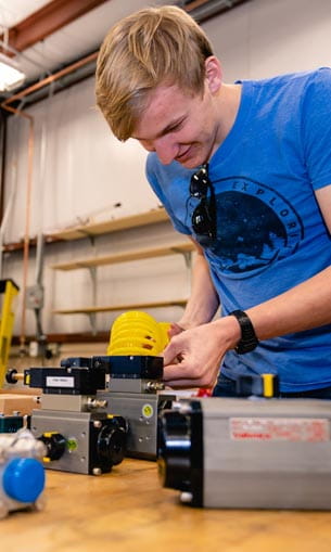 A person in a blue shirt working on a piece of machinery.