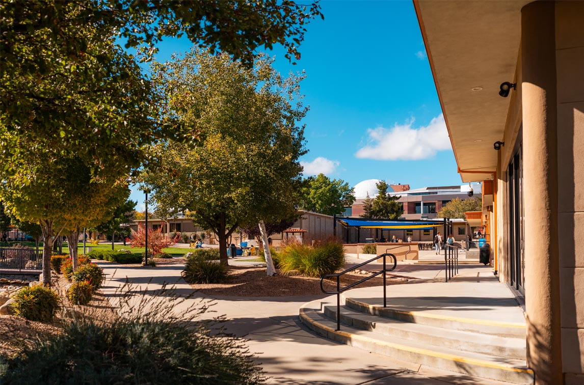 A sunny view of the Prescott campus featuring trees and campus buildings.