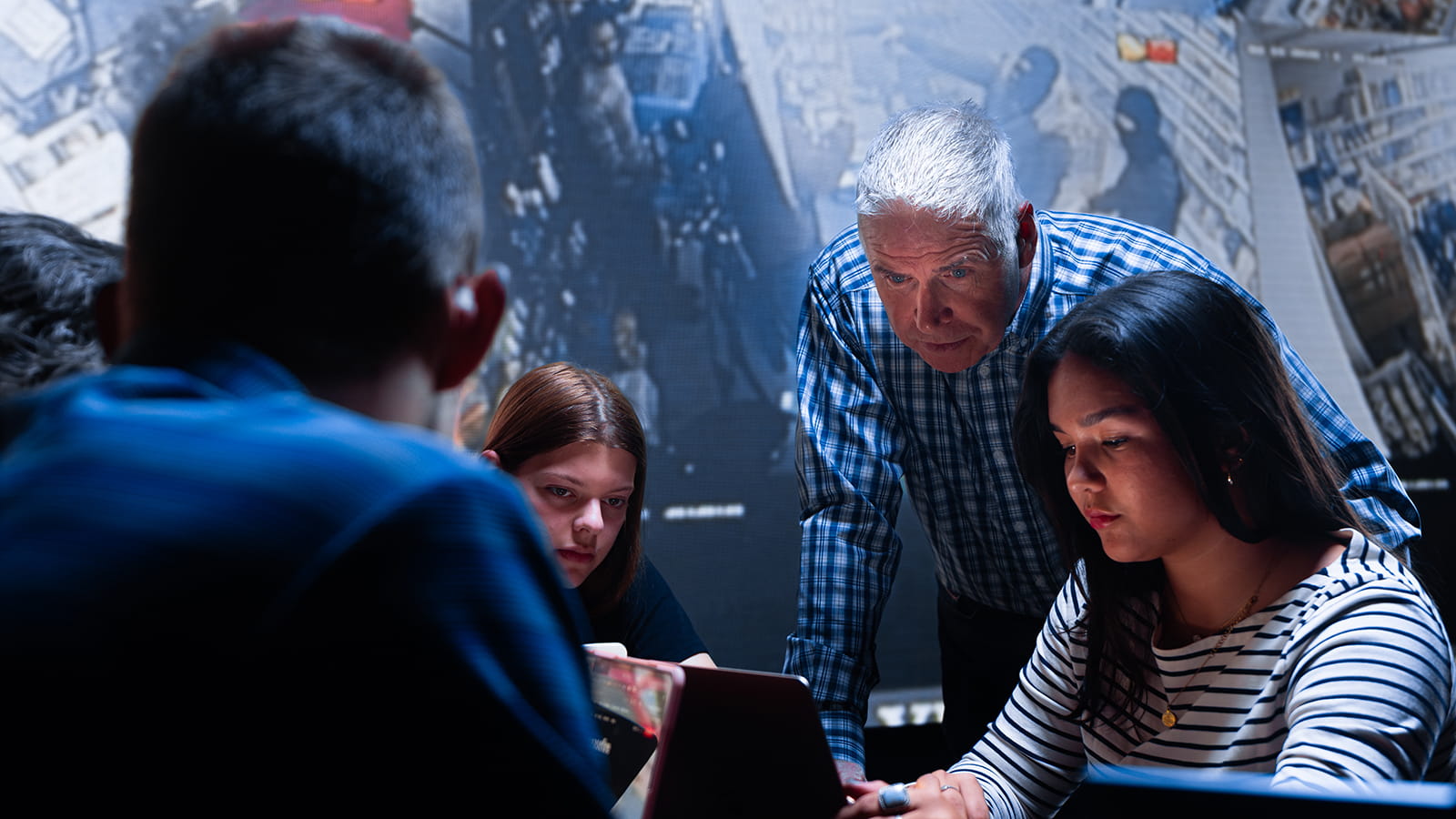 Embry-Riddle faculty works with students around a table in an emergency simulation