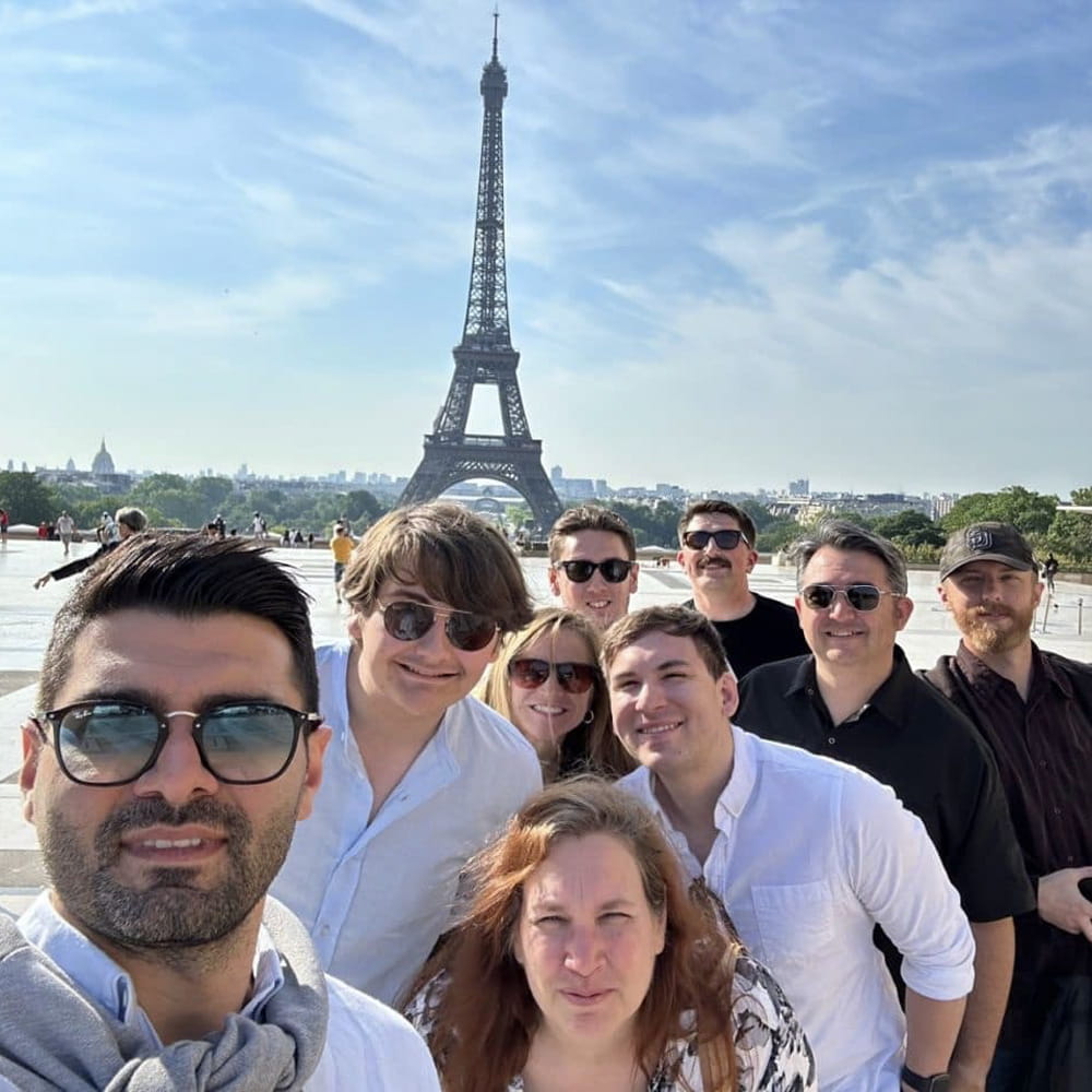 Angelia Keever stansd with a group of friends in front of the Eiffel Tower