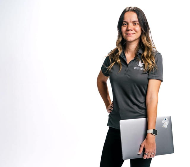 Embry-Riddle student stands with laptop in her hand against a white background