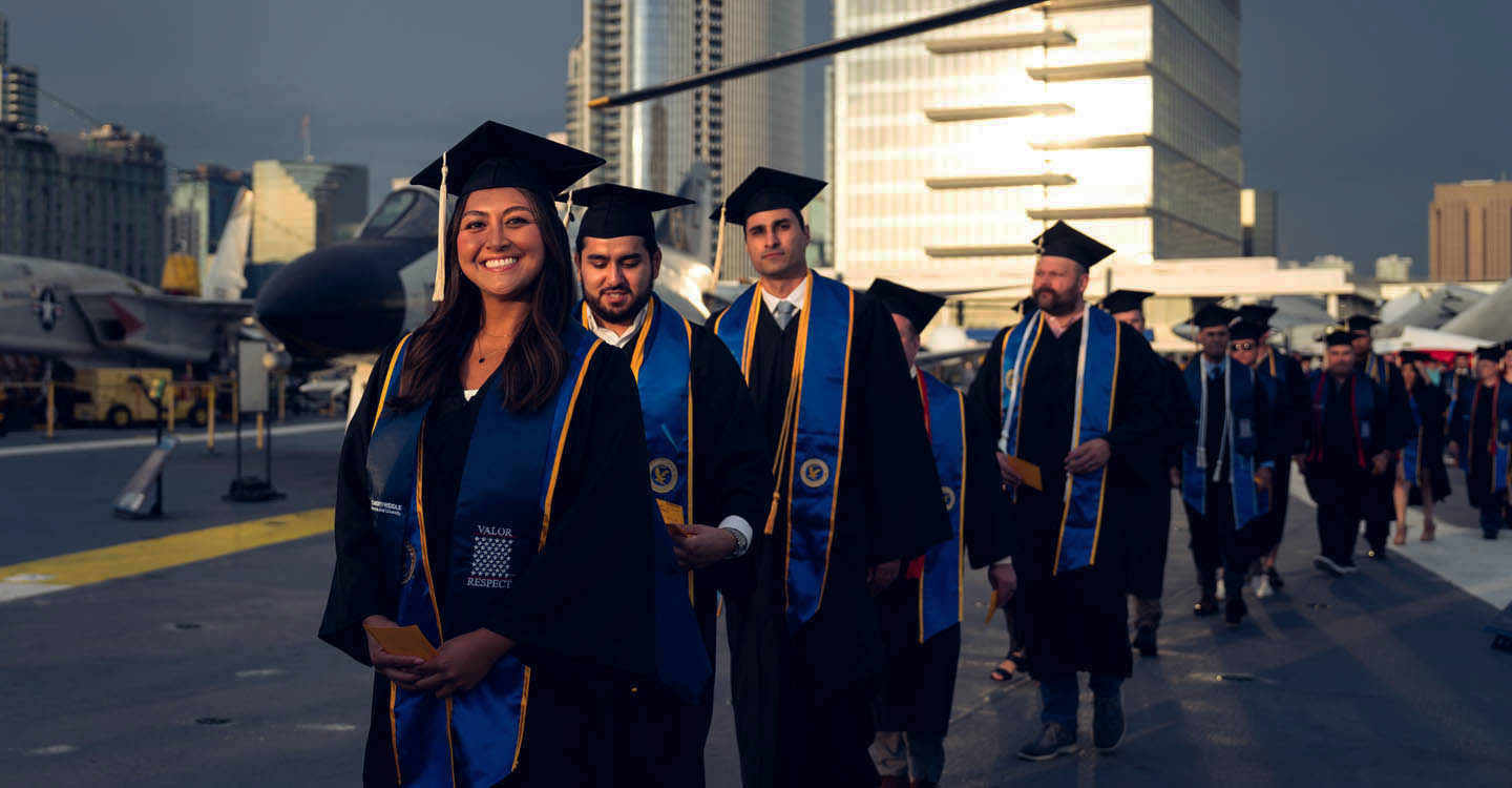 A group of graduates walking outside.