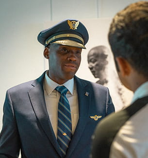 Two pilots meet and pass each other in an airport