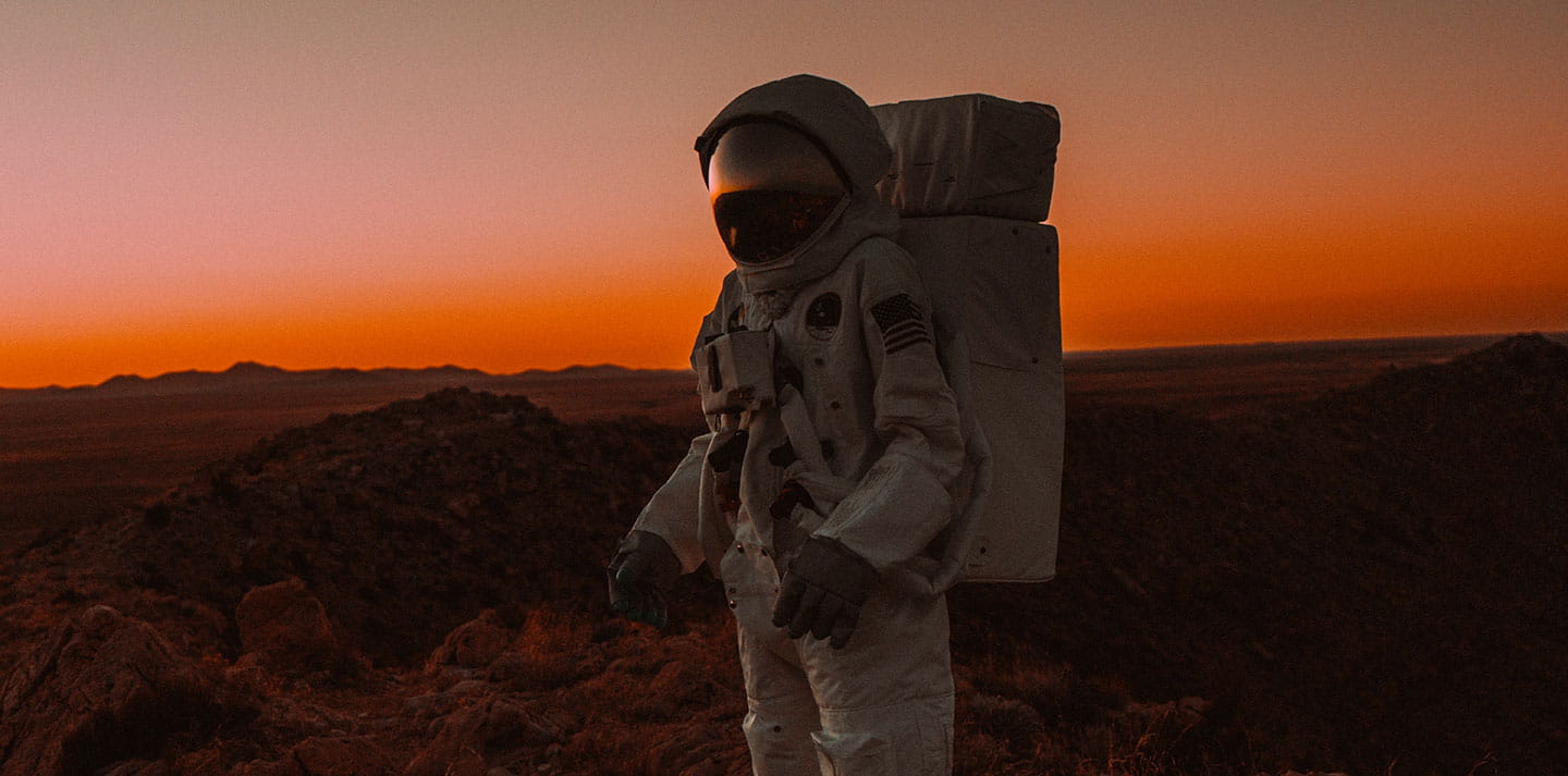 Person wearing space suit in the desert